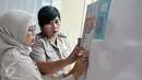 Petugas DVI Polri menempelkan foto properti hasil postmortem sekunder dari jenazah Korban KM Zahro di RS Polri, Jakarta, Selasa (3/1). Penempelan foto properti tersebut bertujuan untuk membantu pengenalan oleh pihak keluarga. (Liputan6.com/Yoppy Renato)