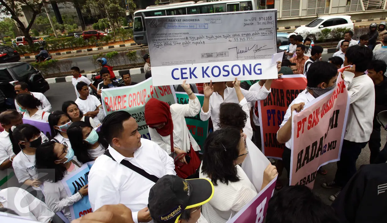 Karyawan dari Partner bisnis Bakrie yang diwakili para investor dan owner unit Hotel Pullman Bali membentangkan replika selembar cek berukuran raksasa di depan gedung Wisma Bakrie 2, Jakarta, Kamis (10/9/2015). (Liputan6.com/Helmi Afandi)