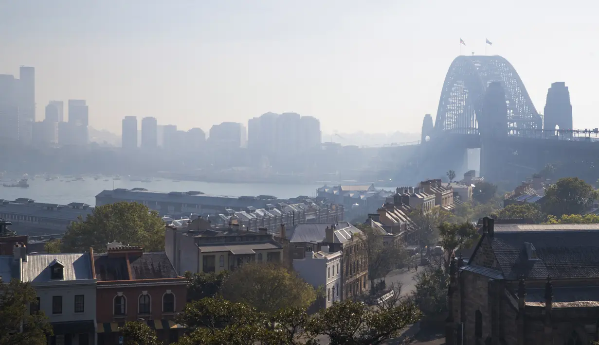 Jembatan Sydney Harbour terlihat diselimuti asap saat kabut asap menyelimuti Sydney Harbour yang indah di Australia, Rabu (13/9/2023). (Steve CHRISTO / AFP)