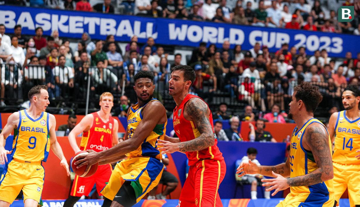 Pebasket Brasil, Lucas Dias (tengah kiri) berusaha mengamankan bola dari pebasket Spanyol, Willy Hernangomez pada laga kedua Grup G Piala Dunia FIBA 2023 di Indonesia Arena, Senayan, Jakarta, Senin (28/08/2023). Spanyol menang atas Brasil dengan skor 96-78. (Bola.com/Bagaskara Lazuardi)