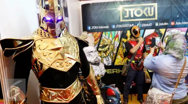 Pengunjung sedang memilih dan mencoba kostum cosplay di stand JTOKU pada gelaran  Popcon Asia 2016 di JCC, Jakarta (14/08). (Liputan6.com/Fery Pradolo)