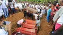 Pemakaman korban banjir dan tanah longsor di Sri Lanka, Minggu (28/5). Saat ini tercatat sudah ada 122 orang yang kehilangan nyawanya akibat bencana yang dipicu oleh hujan lebat di Sri Lanka. (AP Photo)