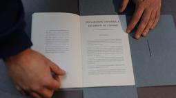 Dokumen tersebut bertuliskan "Declaration Universelle des Droits de l'Homme" (Deklarasi Universal Hak Asasi Manusia) yang kemudian diadopsi dan diproklamirkan oleh Majelis Umum Perserikatan Bangsa-Bangsa pada tanggal 10 Desember 1948. (Dimitar DILKOFF/AFP)
