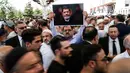 Seorang pria memegang foto mantan Presiden Mesir Mohammed Morsi sebelum menunaikan salat gaib di Masjid Fatih, Istanbul, Selasa (18/6/2019). Mohammed Morsi meninggal saat menjalani sidang atas tuduhan spionase pada Senin, 17 Juni 2019. (AP Photo/Emrah Gurel)