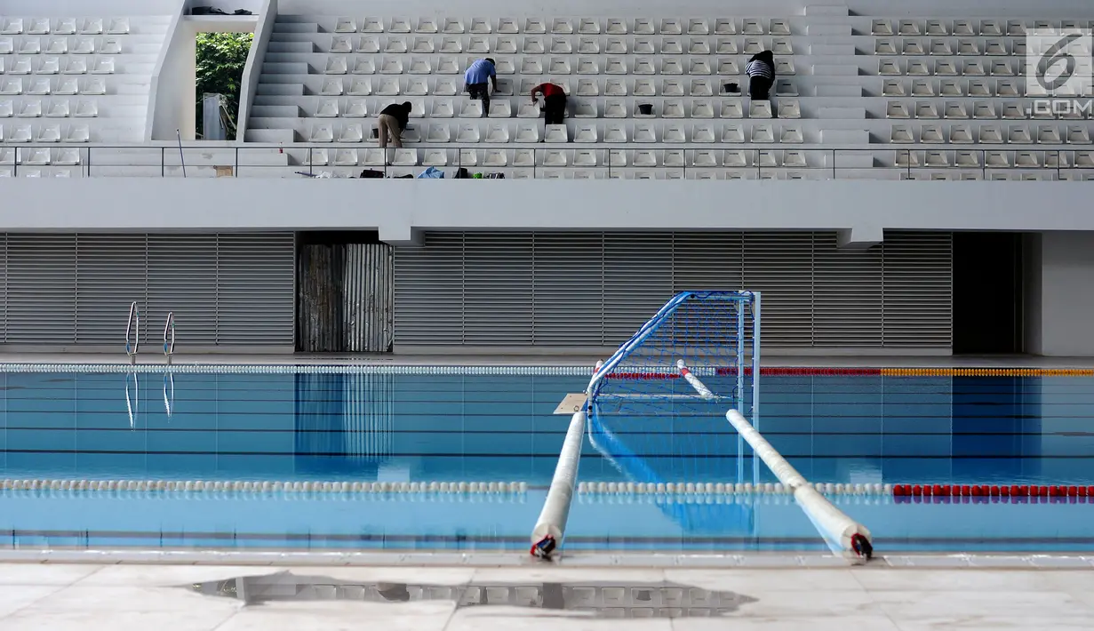 Pekerja membersihkan deretan bangku penonton di Stadion Aquatik Gelora Bung Karno, Jakarta, Jumat (10/11). Renovasi fisik Stadion Aquatik Gelora Bung Karno dinyatakan selesai dan siap digunakan. (Liputan6.com/Helmi Fithriansyah)