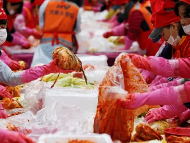 Sejumlah orang membuat Kimchi, hidangan tradisional Korea Selatan, selama Festival Kimchi Seoul di pusat kota Seoul, Jumat (44/11). Kimchi merupakan makanan yang terbuat dari sawi putih atau lobak yang difermentasikan. (REUTERS / Kim Hong-Ji)