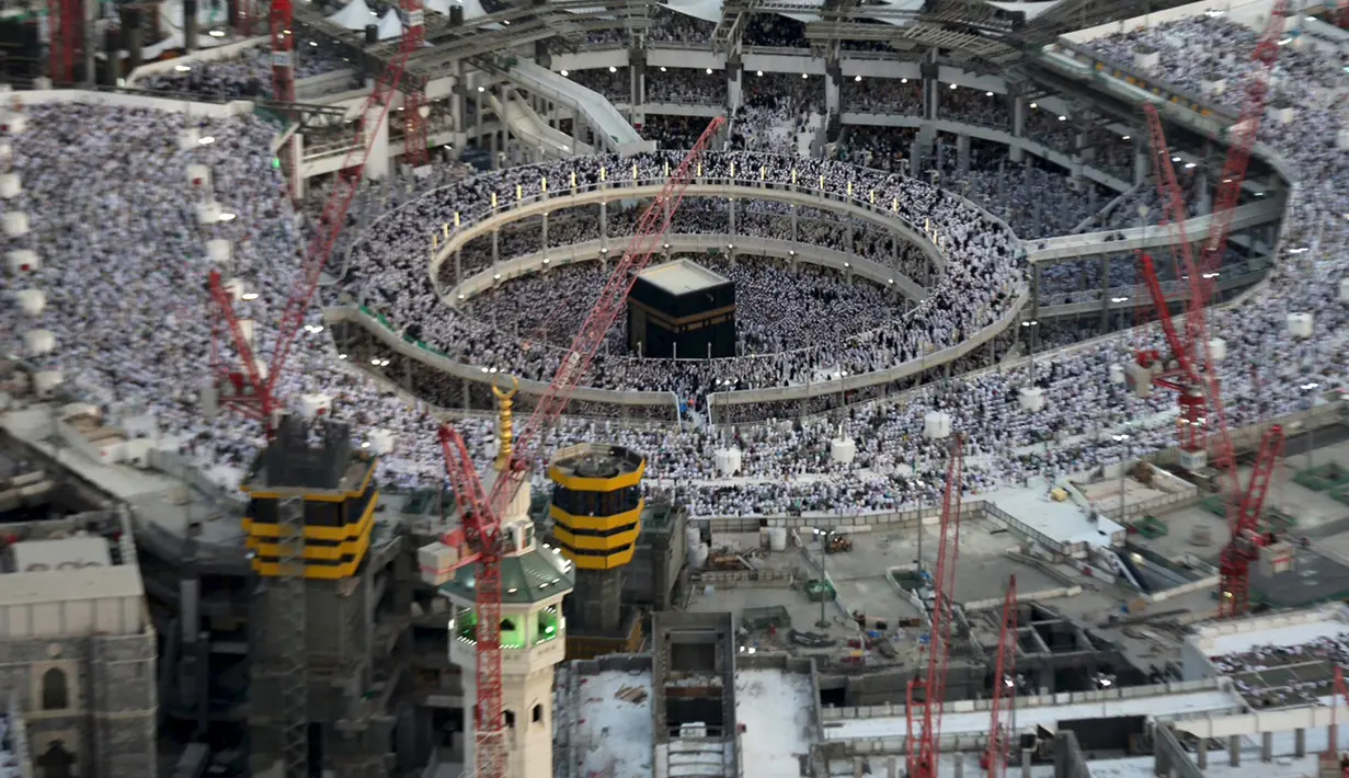 Pemandangan menunjukkan jamaaH berdoa di Masjidil Haram dikelilingi crane konstruksi di Mekah, 14 Juli 2015. Sebuah crane jatuh di Masjidil Haram pada Jumat (11/9), dan menyebabkan sekitar 107 orang tewas, termasuk WNI. (REUTERS/Ali Al Qarni/Files)