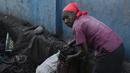 Seorang wanita mengumpulkan arang di depot yang akan dijualnya di pasar lokal, di Les Cayes, Haiti, (25/1). Peraturan tersebut untuk melindungi zona pemotongan kayu. (AP/David McFadden)