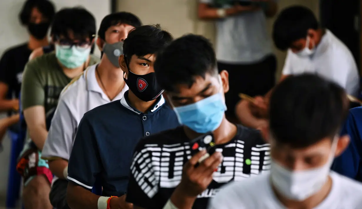 Sejumlah pria muda menunggu untuk menjalani pemeriksaan fisik selama wajib militer tahunan di Bangkok (23/7/2020). (AFP Photo/Lillian Suwanrumpha)
