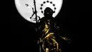 Fenomena super snow moon terlihat di belakang patung Perawan Maria 'Madonnina' di atas Katedral Duomo, Milan, Italia, Selasa (19/2). Super snow moon membuat langit berada di paras paling terang sepanjang tahun. (AP Photo/Luca Bruno)