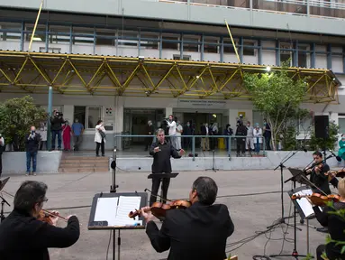 Para anggota ERT (Hellenic Broadcasting Corporation) Modern Music Orchestra memainkan musik di halaman Rumah Sakit Umum Evaggelismos di Athena, Yunani (20/4/2020). Konser digelar oleh ERT Modern Music Orchestra untuk menghormati staf medis dalam perjuangan melawan COVID-19. (Xinhua/Marios Lolos)