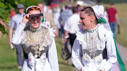 Sejumlah wanita berpakaian tradisional Sorbs saat akan mengikuti kebaktian dalam ritual Whit Monday di Rosenthal, Jerman, Senin (10/6/2019). Whit Monday menjadi hari libur nasional di Jerman dan banyak negara lain. (AP Photo/Jens Meyer)