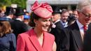 Kate Middleton, Duchess of Cambridge dari Inggris berbicara kepada para tamu di Pesta Taman Kerajaan di Istana Buckingham di London (18/5/2022). Kate Middleton tampak anggun dalam gaun mantel versi koral berwarna merah muda. (AFP/Pool/Dominic Lipinski)