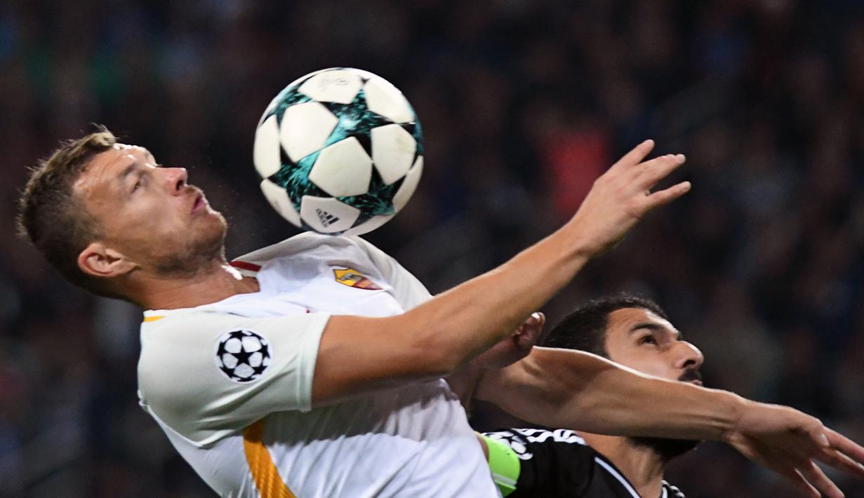 Duel pemain AS Roma, Edin Dzeko (kiri saat berebut bola dengan pemain Qarabag FK, Azerbaijan Rashad Sadygov pada laga grup C Liga Champions di Baki Olimpiya Stadionu, Baku, (27/9/2017). AS Roma menang 2-1. (AFP/Vano Shlamov)