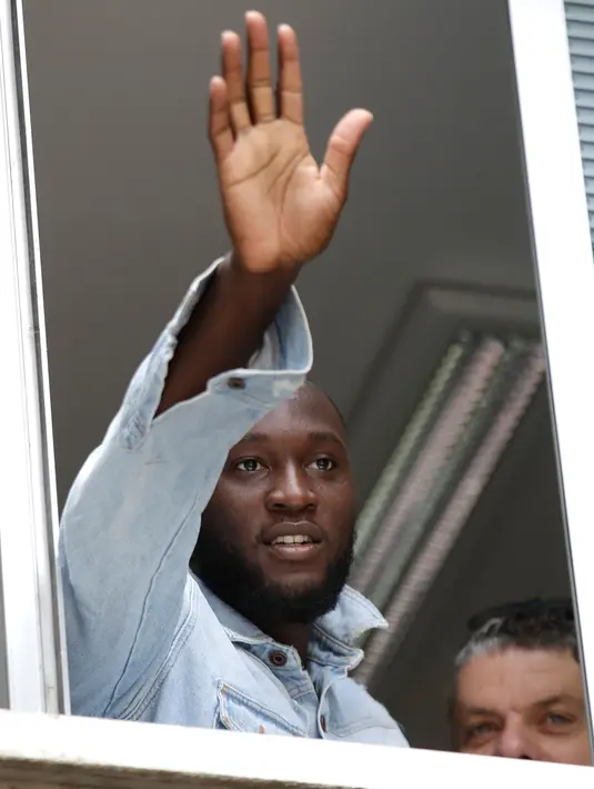 Pesepak bola Romelu Lukaku melambaikan tangannya saat menyapa fans Inter Milan dari jendela markas Komite Olimpiade Italia di Milan, Italia, Kamis (8/8/2019). Penyerang Belgia itu memecahkan rekor transfer Inter Milan yang sudah bertahan hampir dua dekade lamanya. (AP Photo/Luca Bruno)