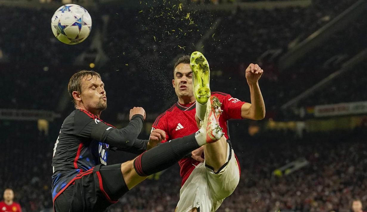 Bek FC Copenhagen, Peter Ankersen (kiri) berebut bola dengan bek Manchester United, Sergio Reguilon pada laga matchday ketiga Grup A Liga Champions 2023/2024 di Old Trafford Stadium, Rabu (25/10/2023) dini hari WIB. (AP Photo/Dave Thompson)