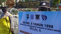 Sejumlah Polwan membawa spanduk bertuliskan Satlantas Polrestabes Surabaya cinta damai saat mengamankan demo UU Cipta Kerja, Kamis (22/10/2020). (Foto: Liputan6.com/Dian Kurniawan)
