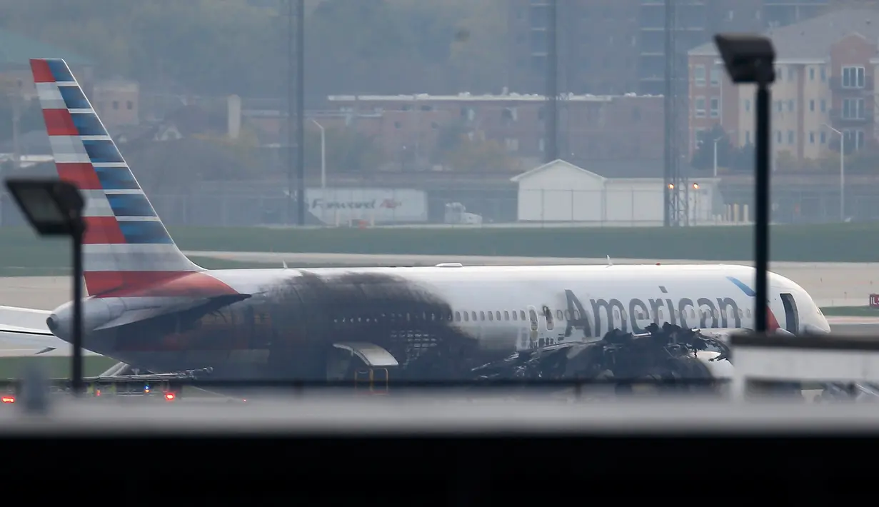Pesawat American Airlines yang terbakar di Bandara O'Hare Chicago, Illinois, AS (28/10). Federal Aviation Administration (FAA) mengatakan pesawat jenis Boeing 767 yang hendak terbang ke Miami mengalami pecah ban dan kerusakan mesin. (REUTERS/Jim muda)