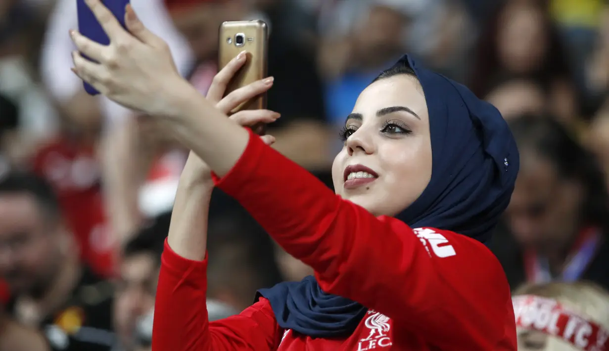 Fans wanita bermain ponsel sebelum pertandingan Piala Super Eropa 2019 antara Liverpool melawan Chelsea di Besiktas Park, Istanbul, Turki (14/8/2019). Dalam pertandingan ini Liverpool menang atas Chelsea lewat drama adu penalti 5-4 (2-2). (AP Photo/Thanassis Stavrakis)