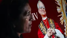 Seorang wanita berdiri di samping gambar Robert Francis Prevost, yang menjadi Paus Leo XIV pada tanggal 8 Mei 2025, di depan katedral Chiclayo di utara Lima pada hari pemilihannya sebagai paus ke-267 Gereja Katolik. (ERNESTO BENAVIDES/AFP)