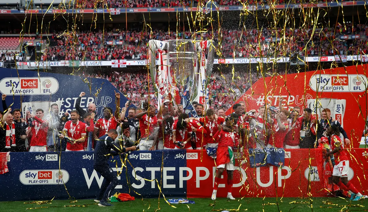 <p>Para pemain Nottingham Forest merayakan dengan trofi Playoff Championship setelah mengalahkan Huddersfield Town pada pertandingan playoff divisi Championship di Stadion Wembley di London, Senin (30/5/2022). Nottingham Forest menang tipis atas Huddersfield Town 1-0. (AFP/Adrian Dennis)</p>