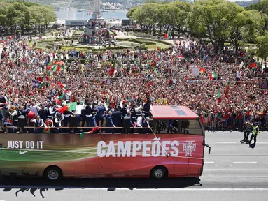 Tim kesebelasan Portugal disambut meriah oleh pendukung mereka saat kembali ke Lisbon, Portugal, Senin (11/7). Ronaldo dkk menyapa pendukung mereka di atas bus terbuka. (REUTERS / Rafael Marchante)