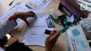 Petugas memeriksa Surat Tanda Registrasi Pekerja (STRP) bagi penumpang di Stasiun Tangerang, Banten, Senin (12/7/2021). Hari pertama penerapan STRP, masih ada warga yang tidak mengetahui persyaratan tersebut hingga membuat penumpang KRL menurun sekitar 30 persen. (Liputan6.com/Angga Yuniar)