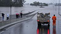 Sebuah kendaraan darurat memblokir akses ke Jembatan Windsor yang banjir di pinggiran Sydney, Australia, Senin (4/7/2022). Ratusan rumah terendam di dalam dan sekitar kota terbesar Australia itu dalam keadaan darurat banjir yang berdampak pada 50.000 orang, kata para pejabat. (AP Photo/Mark Baker)