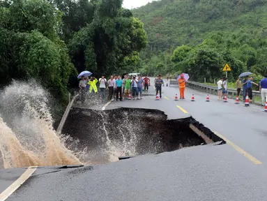 Sebuah jalan terlihat rusak parah akibat hujan lebat dari Topan Nepartak di Fuzhou, Fujian, Tiongkok (9/7). Ratusan ribu warga terpaksa mengungsi akibat topan ini. (REUTERS)