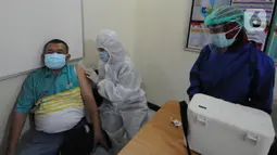 Petugas menyuntikkan vaksin covid-19 kepada warga di Polsek Pamulang, Tangerang Selatan, Kamis (1/7/2021). Sebanyak 10 ribu dosis vaksin untuk warga 18 tahun ke atas dibagikan di wilayah Polres Tangerang Selatan dalam rangka HUT Bhayangkara Ke-75 yang jatuh pada hari ini. (merdeka.com/Arie Basuki)