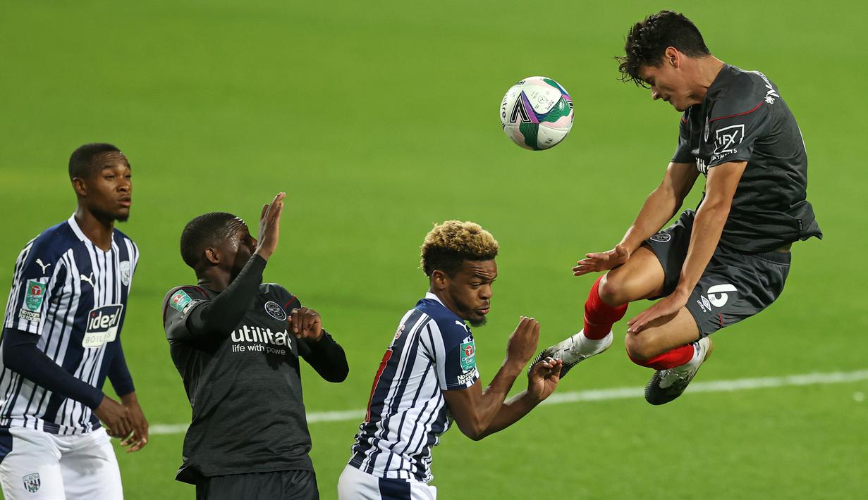 Gelandang West Brom, Grady Diangana, berebut bola dengan gelandang Brentford, Christian Norgaard, dalam laga Piala Inggris di venue The Hawthorns, Rabu (23/9/2020) dini hari WIB. West Brom kalah 6-7 atas Brentford lewat adu penalti. (AFP/Carl Recine/pool)