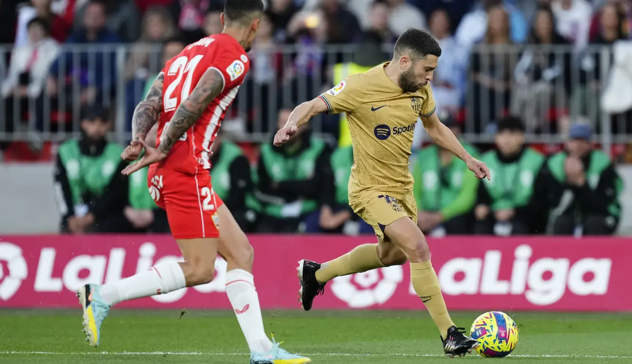 Bek Barcelona Jordi Alba berebut bola dengan bek Almeria Chumi pada pekan ke-23 Liga Spanyol di Power Horse Stadium, Senin dini hari WIB (27/2/2023). Butuh kemenangan, Barcelona langsung mengambil kendali permainan sejak awal laga. (AP Photo/Jose Breton)