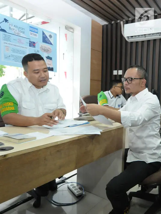 Menteri Ketenagakerjaan M Hanif Dhakiri (kanan) mengecek berkas aduan bersama petugas Posko Peduli Lebaran 2018 di Gedung B Kemenaker, Jakarta, Senin (28/5). Posko juga menerima aduan pemasalahan seputar THR. (Liputan6.com/Helmi Fithriansyah)