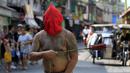 Seorang penganut Kristen Katolik Filipina berjalan sambil memakai topeng di kota Mandaluyong, Filipina, (24/3). Tradisi cambuk merupakan tradisi yang dilakukan oleh beberapa umat Katolik Filipina untuk menyambut hari Paskah. (REUTERS / Romeo Ranoco)