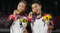 Ganda putri Indonesia Greysia Polii (kiri) dan Apriyani Rahayu saat upacara penyerahan medali cabang badminton ganda putri Olimpiade Tokyo 2020 di Musashino Forest Sport, Senin (2/8/2021). Greysia / Apriyani merebut emas usai menang atas pasangan China Cheng Qingchen/Jia Yi Fan. (AP/Dita Alangkara)