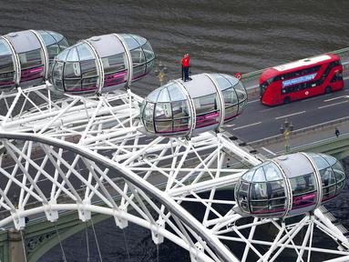 Legenda Inggris yang berjaya di Piala Dunia 1966 Geoff Hurst berdiri di atas pod komedi putar London Eye memandang ke arah Stadion Wembley di London (9/7/2021). Geoff Hurst tampil mengenakan jersey Inggris di final Piala Dunia 1966. (Dominic Lipinski/PA via AP)