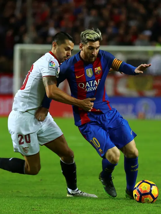 Penyerang Barcelona, Lionel Messi berusaha melewati gelandang  Sevilla, Vitolo pada lanjutan La Liga spanyol di Stadion Sanchez Pizjuan,  Spanyol, (7/11). Barcelona menang atas Sevilla 2-1. (REUTERS/ Marcelo del Pozo)