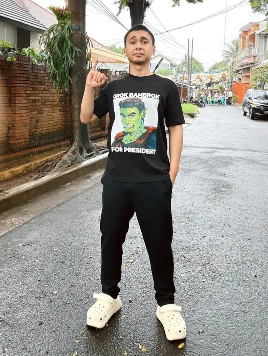 Raditya Dika pun memamerkan jari kelingkingnya yang ternoda tinta setelah coblosan dalam sebuah foto. Ia mengenakan kaus hitam bercorak, dipadukan dengan celana jeans yang juga berwarna hitam, dan sandal crocs putih. [Foto: Instagram/raditya_dika]