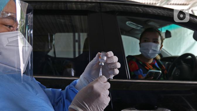 Vaksinator menyiapkan vaksin COVID-19 untuk warga lanjut usia saat vaksinasi secara drive-thru di area parkir Hall C JIExpo Kemayoran, Jakarta, Rabu (3/3/2021). Pelaksanaan vaksinasi drive thru bertujuan meningkatkan partisipasi Lansia untuk divaksin covid-19. (Liputan6.com/Herman Zakharia)