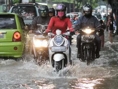 Pengendara motor menerobos genangan air di Pejaten Raya, Jakarta, Selasa (4/10). Akibat curah hujan yang tinggi menyebabkan sejumlah titik di Jakarta tergenang air. (Liputan6.com/Yoppy Renato)