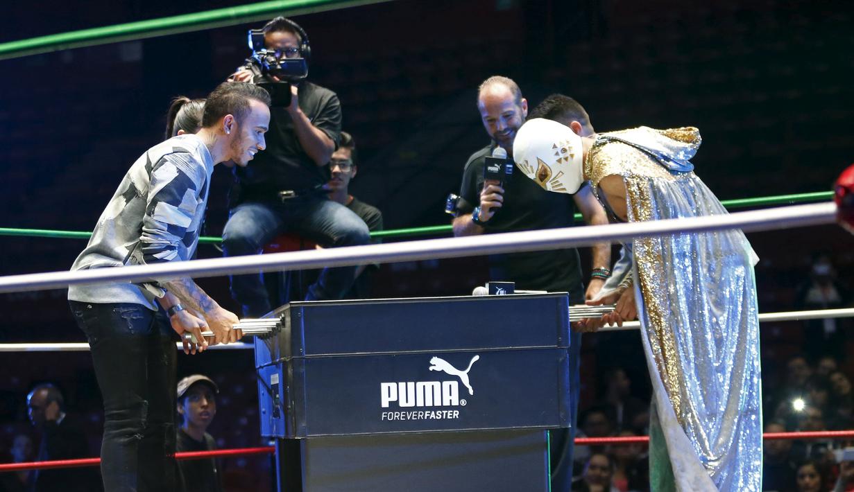 Lewis Hamilton bermain sepakbola meja dengan seorang bintang WWE di Coliseo Arena, Mexico City, (28/10/2015). (Reuters/Henry Romero)
