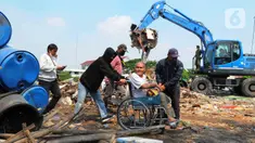 Warga melintas dekat alat berat saat menghancurkan bangunan yang terdampak proyek sodetan Ciliwung menuju Kanal Banjir Timur (KBT) di Kelurahan Cipinang Besar Selatan, Jakarta, Kamis (12/1/2023). Warga ber-KTP DKI Jakarta akan direlokasi ke rumah susun Cipinang Besar Utara, sedangkan para pedagang akan ditempatkan di pasar PD Pasar Jaya. (merdeka.com/Imam Buhori)