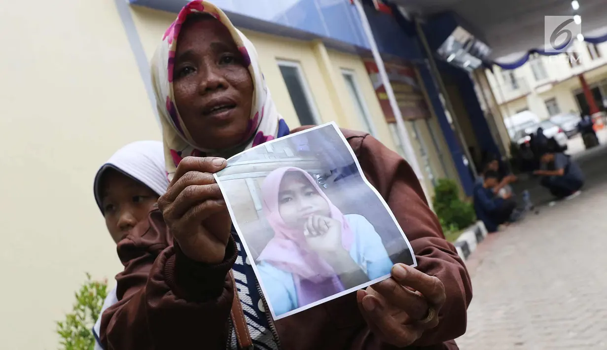 Keluarga menunjukkan foto korban kebakaran pabrik kembang api di RS Polri Sukanto Kramat Jati, Jakarta Timur, Jumat (27/10).  Keluarga yang melaporkan kehilangan sejak Kamis (26/10/2017) telah mencapai 32 orang. (Liputan6.com/Immanuel Antonius)