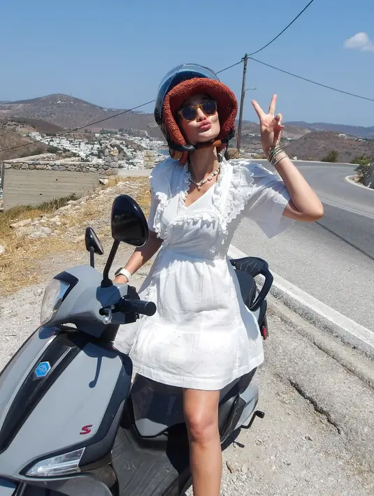 Luna Maya tak ragu naik motor mengenakan mini dress putih berlengan lebar dan lace collar yang manis [@lunamaya]