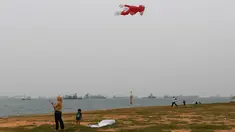 Warga menerbangkan layang-layang saat kabut asap menyelimuti kota Singapura (15/9/2019). Polusi dari kebakaran hutan di Indonesia mendorong kualitas udara Singapura ke tingkat yang tidak sehat untuk pertama kalinya dalam tiga tahun. (AFP Photo/Roslan Rahman)