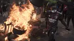 Seorang demonstran berjalan melewati barikade yang dibakar selama protes untuk mendukung pemimpin oposisi utama Ousmane Sonko di Dakar, Senegal, Senin (29/5/2023). (AP Photo/Leo Correa)