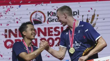 Juara tunggal putra Denmark Viktor Axelsen berjabat tangan dengan runner up dari Indonesia Anthony Sinisuka Ginting saat penyerahan medali usai final tunggal putra Indonesia Open 2023 di Istora Senayan, Minggu (18/6/2023). (AP Photo/Tatan Syuflana)