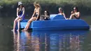 Sejumlah wanita bersantai di perahu kayuh di The Serpentine di Hyde Park di London, Rabu, (12/8/2020). Peringatan badai masih berlaku untuk sebagian besar Inggris pada hari Rabu, sementara suhu tinggi diperkirakan lagi di banyak bagian Inggris. ( AP Photo / Kirsty Wigglesworth)