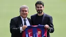 Gelandang baru FC Barcelona Ilkay Gundogan (kanan) berfoto bersama Presiden FC Barcelona Joan Laporta saat presentasi resminya di tempat latihan Joan Gamper, Sant Joan Despi, Spanyol, Senin (17/7/2023). Ilkay Gundogan resmi diperkenalkan Barcelona. (LLUIS GENE/AFP)