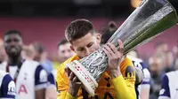 Kiper Tottenham Guglielmo Vicario mencium trofi Liga Europa&nbsp;setelah mengalahkan Manchester United di San Mames,&nbsp;Kamis (22/5/2025). (AP Photo/Jose Breton)